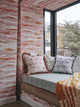 Cozy window seat corner in the Christopher Farr Cloth showroom on King's Road, featuring apricot-toned Island Atmosphere wallpaper from the Fogo Island Collection. The space showcases 'Island Atmosphere Cobalt' by Nick Herder, creating a warm, inviting interior. Photographed by Christopher Horwood at 585 King's Road.